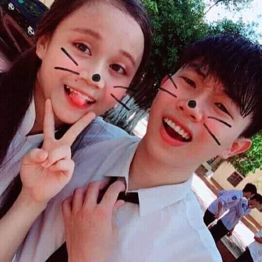 Hai đứa trong áo đồng phục, mặt vẽ râu mèo