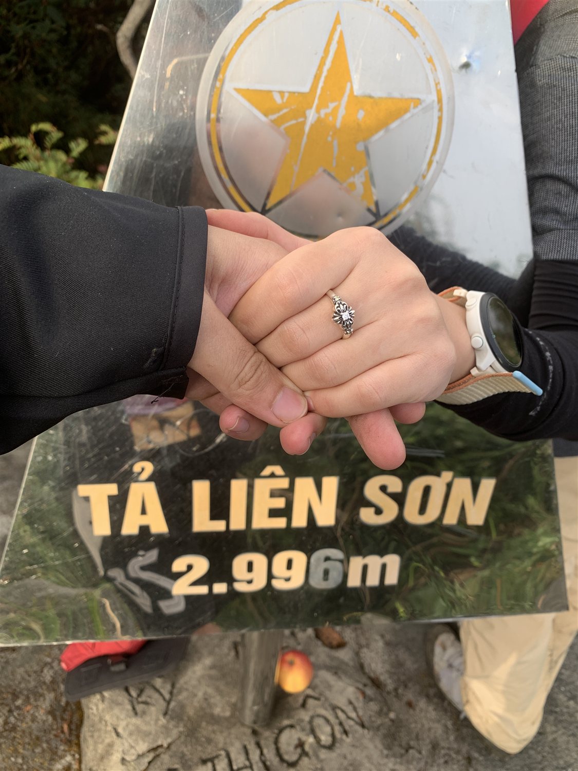 Hai bàn tay nắm nhau, chiếc nhẫn cầu hôn trên cột mốc Tả Liên Sơn